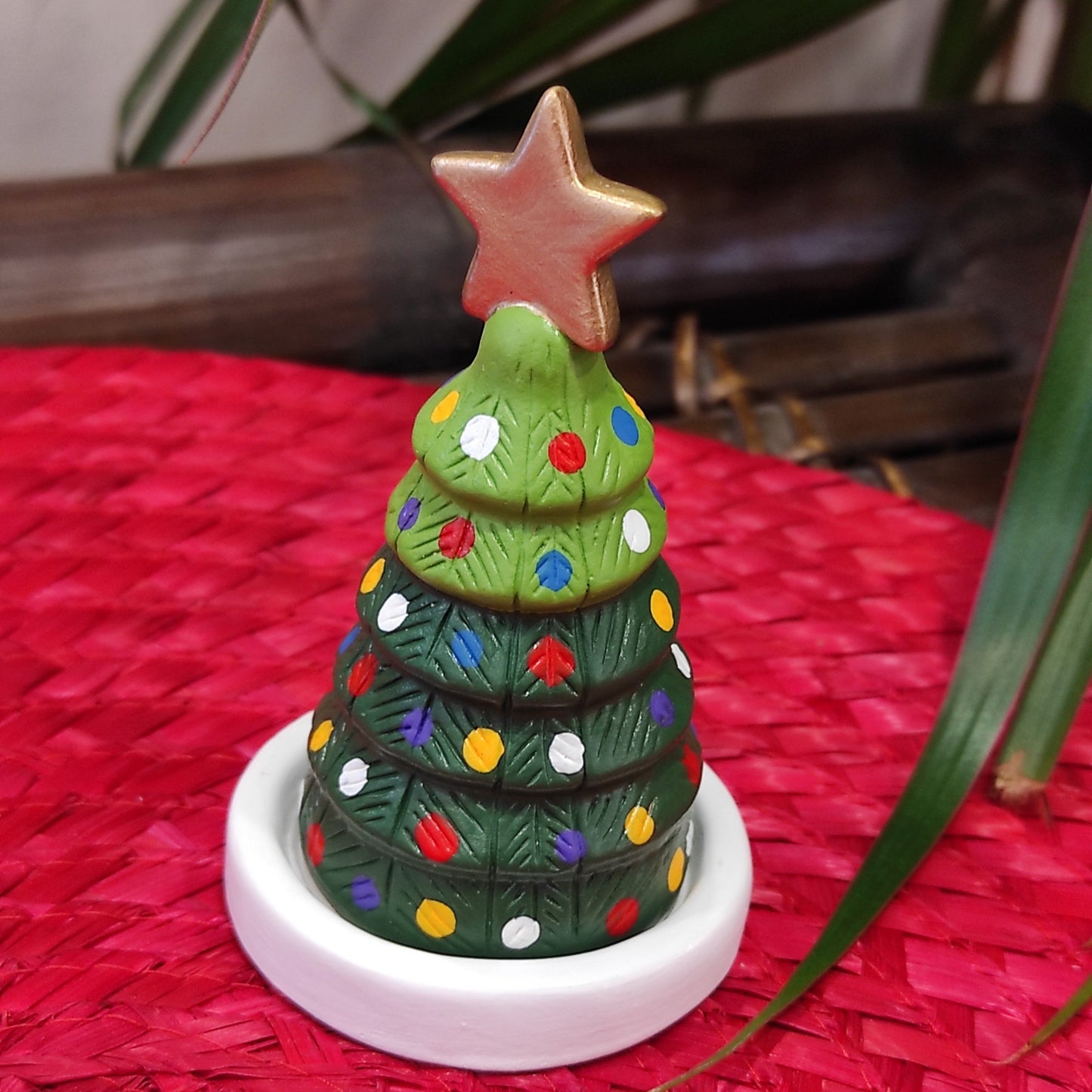 Presepe compatto in terracotta con dolci personaggi che si nascondo sotto un abete.Fatto a mano da artigiani in Perù