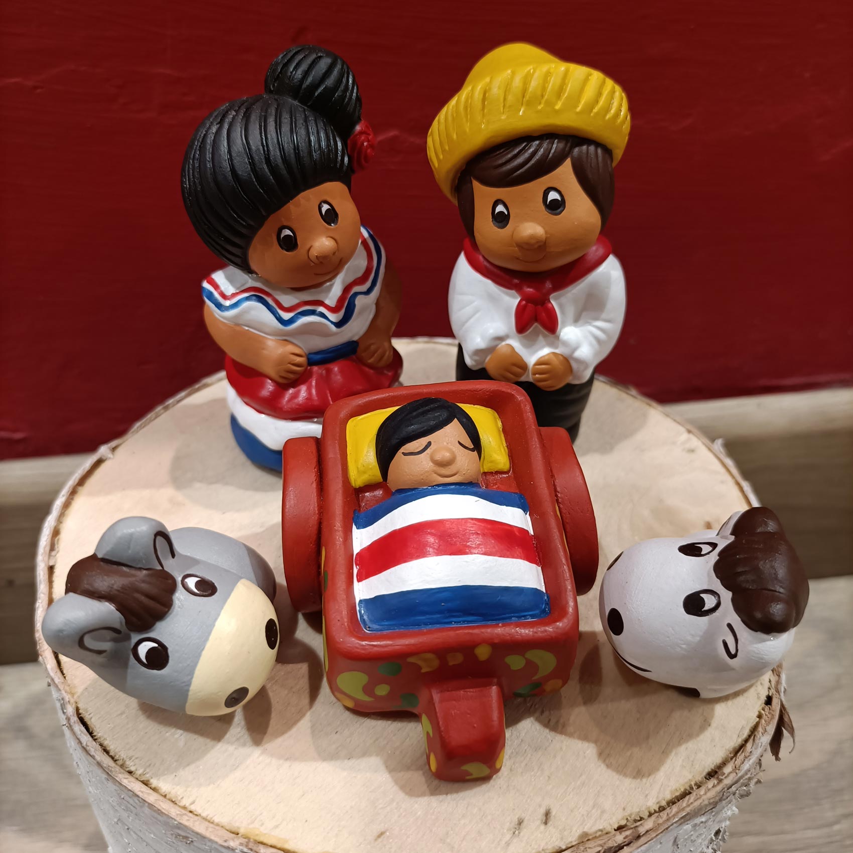 Natività in terracotta con colori accessi in cui i personaggi vestono i vestiti tradizionali del Paraguay